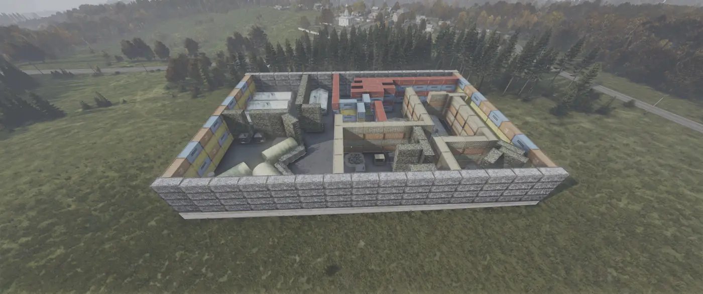 An aerial view of a compound walled with stacked shipping containers in the countryside on Is Dead