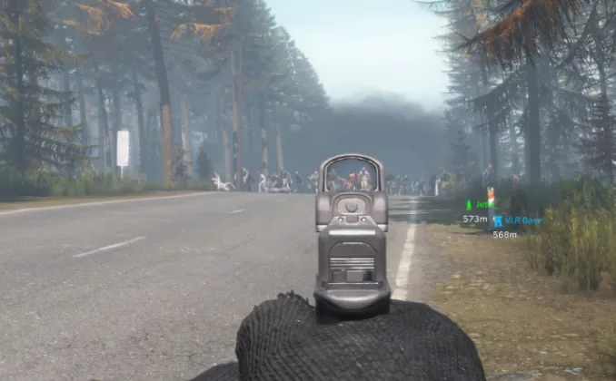 First-person view down a red dot sight at a horde of infected walking up a road on Is Dead